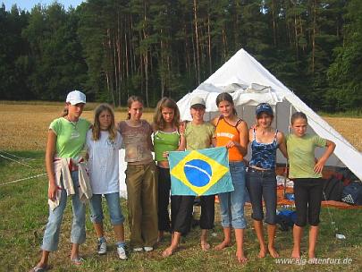 [Foto vom Zeltlager: Die mittleren Mädels mit einer Brasilien-Flagge vor ihrem Zelt]