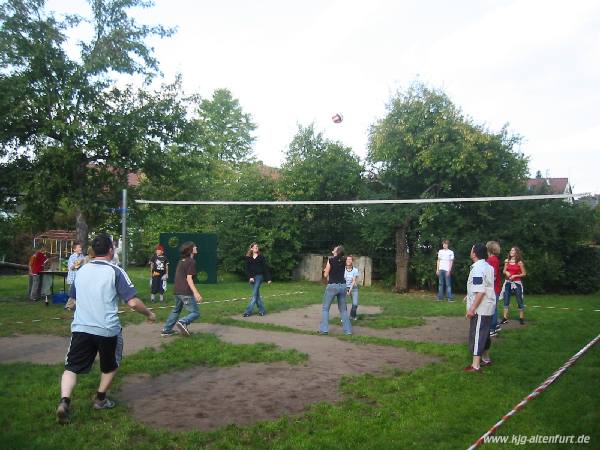Jugendliche une Erwachsene spielen miteinander Volleyball