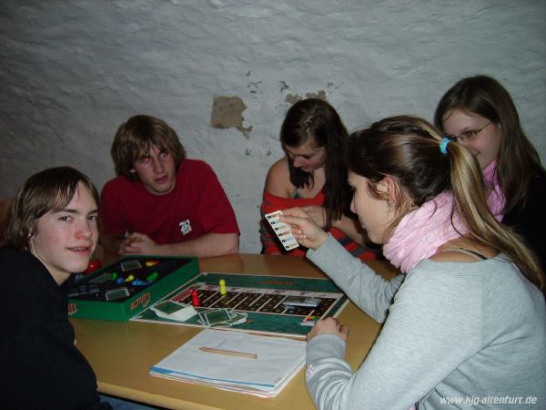 Mehrere Jugendliche spielen im Schlosskeller ein Brettspiel