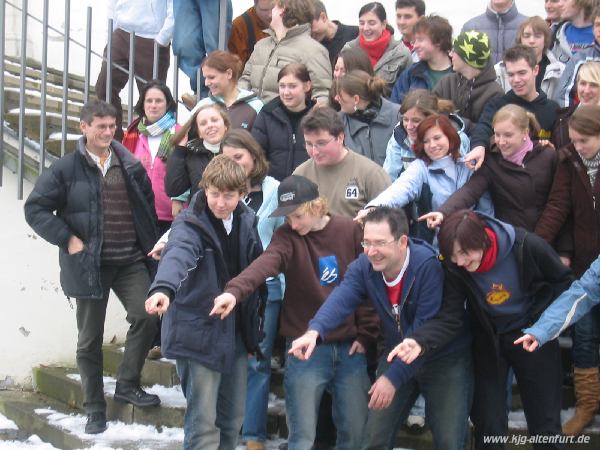 Teil-Gruppenfoto: Alle zeigen mit dem Arm nach links unten