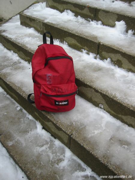 Bennys roter Rucksack auf der verschneiten Treppe