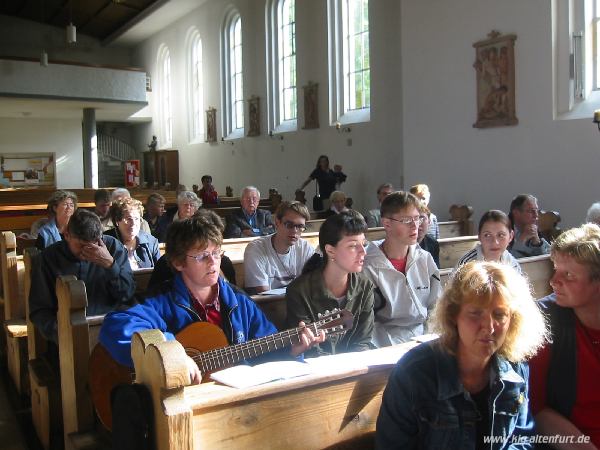 Die Gäste aus Russland sitzen in der Kirche St. Sebald, Schwester Maria, die sie begleitet, spielt auf der Gitarre