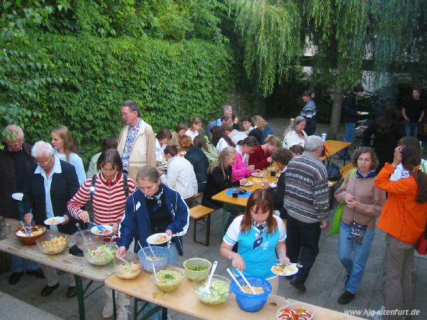 Grillabend in Fischbach. Gäste, Gastfamilien und weitere Pfarrangehörige bedienen sich am Salatbuffett bzw. sitzen an ihren Tischen