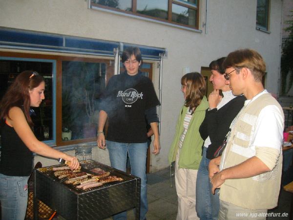 Flora aus Russland wendet Würstchen auf dem Grill