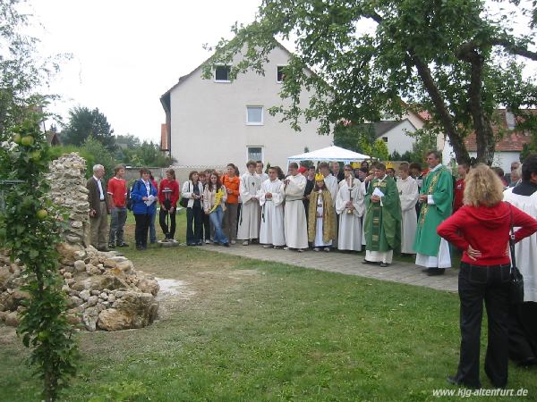 Gäste, Gottesdienstbesucher und Ministranten stehen vor der Lourdes-Grotte, die nach dem Jugendgottesdienst gesegnet wurde