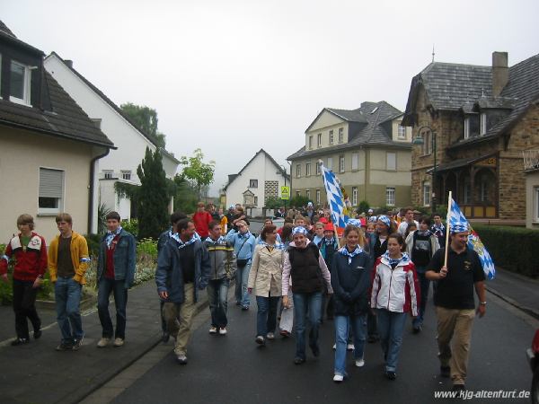 Eine Schar Jugendliche laufen durch eine Straße in Ahrweiler. Sie tragen blau-weiße Halstücher und haben zwei große Bayern-Fahnen dabei
