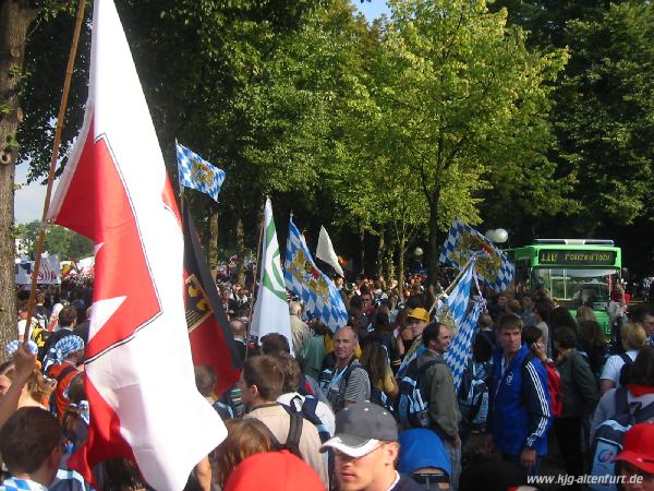 Eine große Menschenmenge mit vielen Fahnen auf dem Weg zum Eröffnungsgottesdienst in Bonn