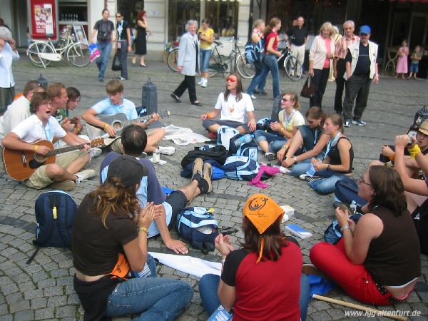 Jugendliche sitzen mit mehreren Gitarren in der Düsseldorfer Fußgängerzone und singen
