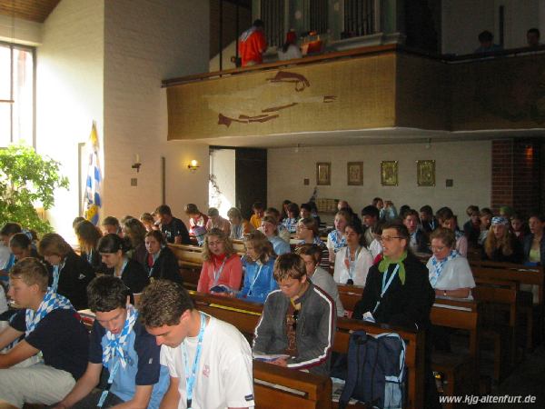 Die Jugendlichen sitzen in Kirchenbänken und singen aus dem Liederbuch zum WJT