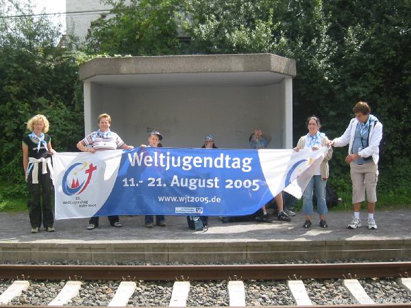 Einige Jugendliche halten am Bahnhof in Ahrweiler eine großes Stoff-Transparent, auf dem der Schriftzug "Weltjugendtag 2005" und das offizielle Logo zu sehen ist