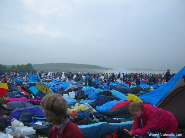 Das Marienfeld voller schlafender Pilger, am Rand des Feldes hängen noch dichte Nebelschwaden