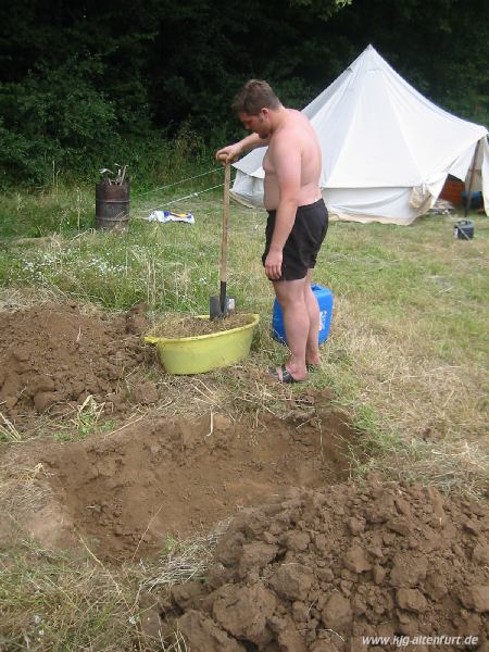 Christian mit einem Spaten, beim graben eines Loches, daneben viel Erdaushub