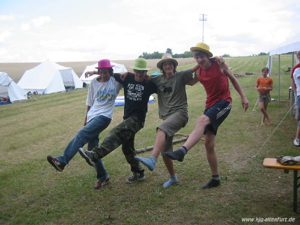 Vier Teilnehmer mit bunten Hüten tanzen