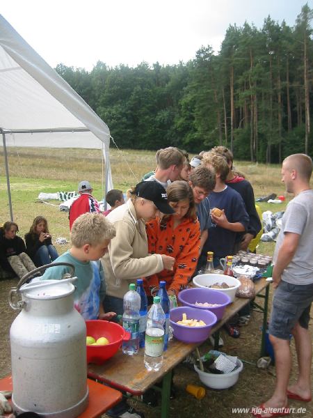 An einem Biertisch können sich die Teilnehmer Grot, Wurst, Käse und Äpfel für das letzte Mittagessen holen