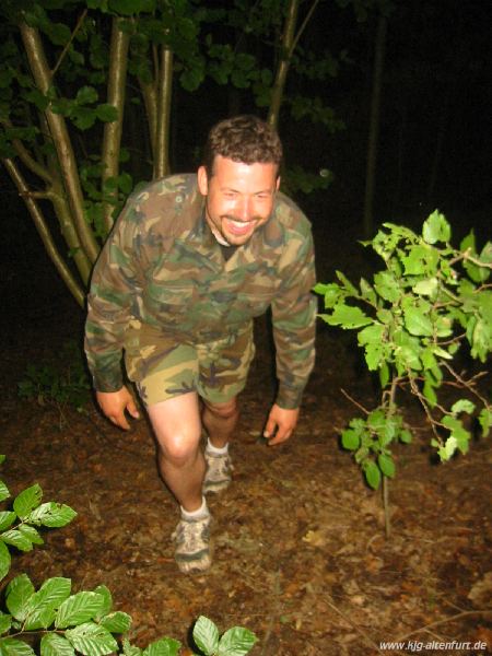 Martin kommt in einem Tarnanzug aus dem Wald