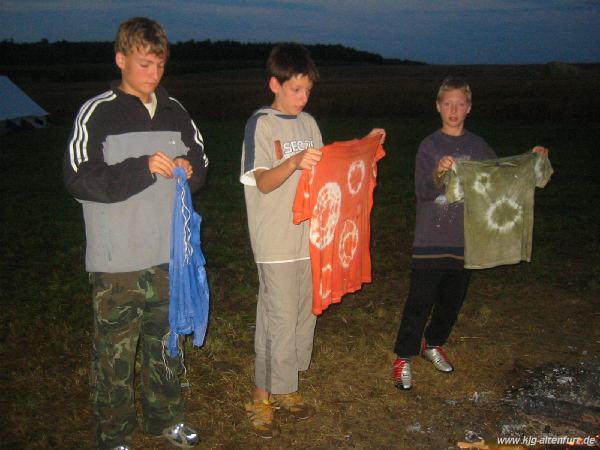 Drei Jungs halten ihr gebatikten T-Shirts