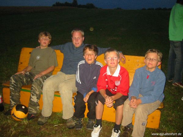 Andreas sitzt mit vier Jungs am Lagefeuer