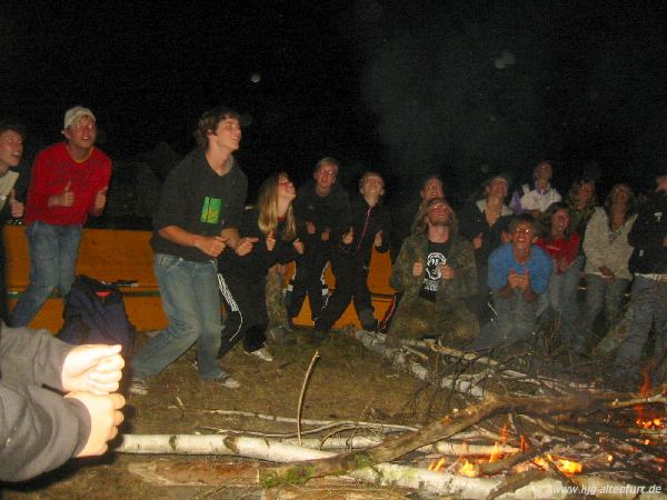 Die Teilnehmer tanzen beim 'Singing in the rain' in seltsamen Bewegungen am Feuer